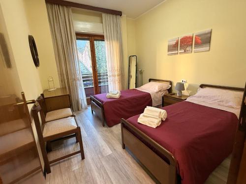a room with two beds and a chair and a window at AlipierHome Bernina Gateway Comfort e Spazio vicino al Trenino Rosso in Tirano
