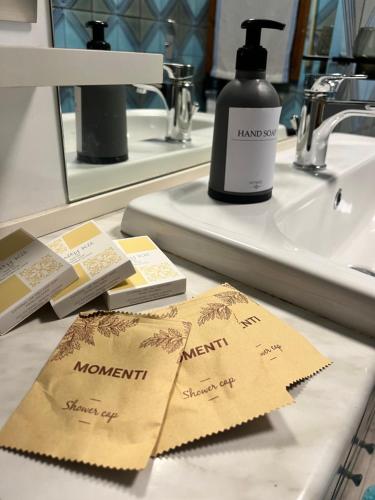 a bathroom counter with a bottle of mouthwash on a sink at AlipierHome Bernina Gateway Comfort e Spazio vicino al Trenino Rosso in Tirano