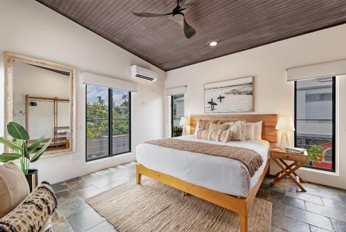 a bedroom with a large bed and windows at The Boho Casa - Beachside Retreat with Pool in Darwin