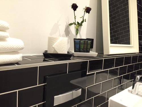 a bathroom with a black counter with a vase of flowers at Steffens Herrnmuehle in Alzenau