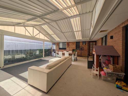 a living room with a couch and a large window at Surf Stay in Singleton