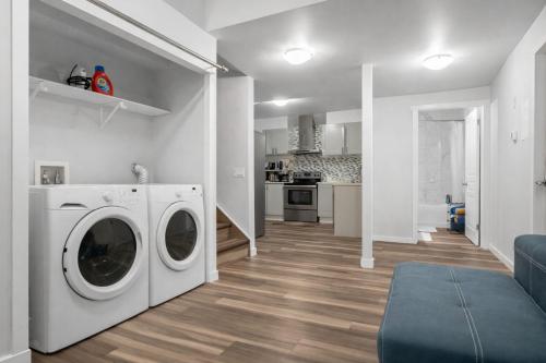 a living room with a washer and dryer in a house at Bright 2BR Suite Near YYC & Mall in Calgary