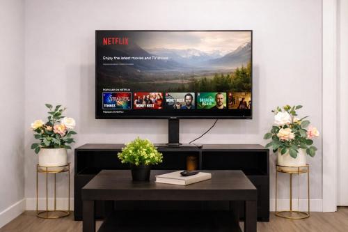 a living room with a television on a wall at Bright 2BR Suite Near YYC & Mall in Calgary
