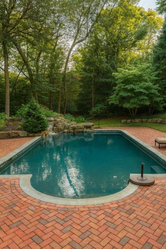 a small swimming pool in a brick yard with trees at Luxury 7-Bedroom Villa with Pool in Glen Head in Glen Head