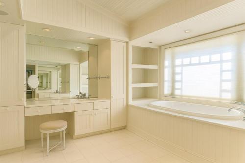 a bathroom with a tub and a sink and a mirror at Luxury 7-Bedroom Villa with Pool in Glen Head in Glen Head