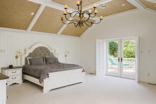a bedroom with a bed and a chandelier at Luxury 7-Bedroom Villa with Pool in Glen Head in Glen Head