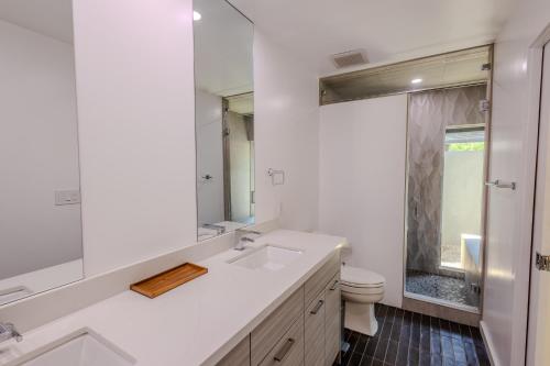 a white bathroom with a sink and a toilet at Luxury Scottsdale Retreat with Heated Pool, Hot Tub, Fire Pit & Game Room & Sleeps 12 in Scottsdale