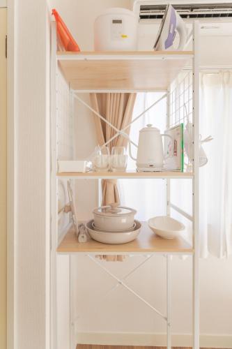 a shelf with dishes and other items on it at Hotel Emile 101 in Tachikawa
