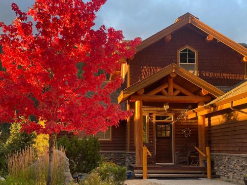 a house with a red tree in front of it at Morrisey Chalet at Sun Peaks in Sun Peaks