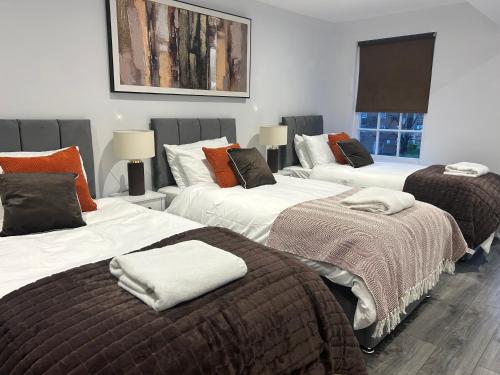 a group of three beds in a room at Tavistock House-Parking-Sleeps 7-Central in Bedford