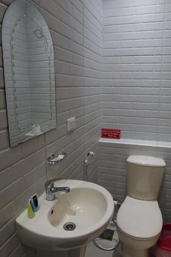 a bathroom with a white toilet and a sink at Meramees Hotel in Cairo