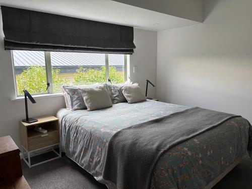 a bedroom with a large bed and a window at Seaview on Sealy Apartment in Napier