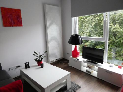 a living room with a tv and a white table at Cube Apartamenty in Lublin