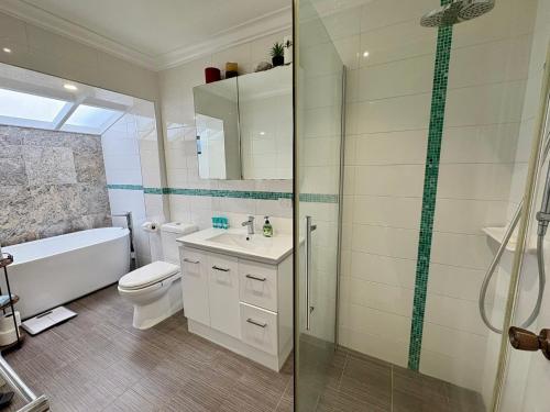 a bathroom with a toilet and a sink and a shower at Beachside Escape - Broadwater in Broadwater