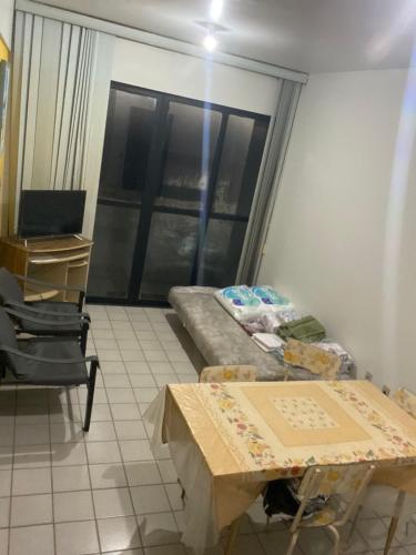 a room with a table and a bed and a window at Apartamento com piscina e churrasqueira privativas in Cabedelo
