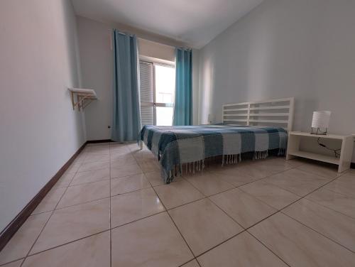 a bedroom with a bed and a large tile floor at Apartamento Espargos in Espargos