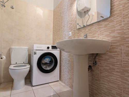 a bathroom with a washing machine and a sink at Apartamento Espargos in Espargos
