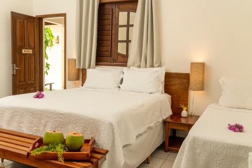 a hotel room with two beds and a mirror at Espaço Fateixa in Jericoacoara