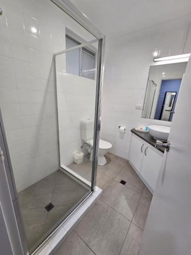 a bathroom with a shower and a toilet and a sink at Blue Violet Motor Inn in Toowoomba
