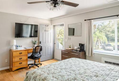 a bedroom with a bed and a desk and a ceiling fan at Studio retreat by the river in Tampa