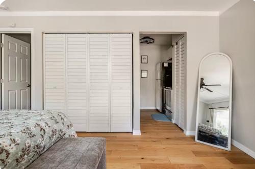 a bedroom with a large white closet and a mirror at Studio retreat by the river in Tampa