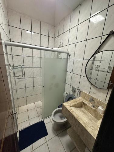 a bathroom with a toilet and a sink and a mirror at Casa no Centro in Corumbá