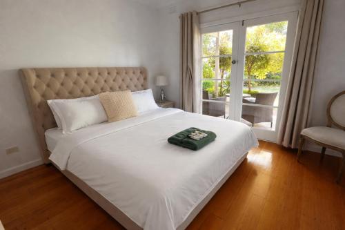 a bedroom with a large white bed with a window at Entire Beachfront Vacation House in McCrae