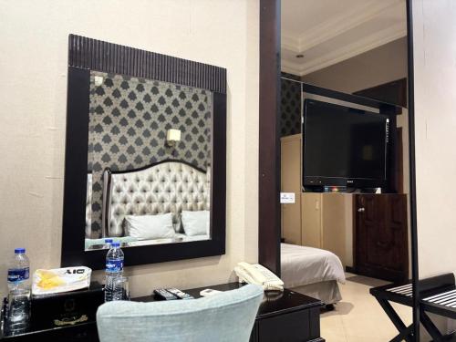 a large mirror in a hotel room with a bedroom at Pavotel Style Naz Hotel in Kamparganya