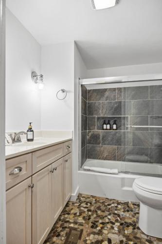 a bathroom with a toilet and a sink and a tub at Riverfront Fire Pit Hot Tub Fishing Kayaks PacMan in Hopkins Spring