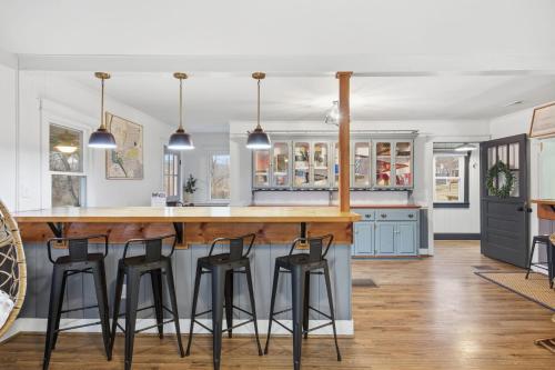 a kitchen with a large wooden bar with stools at Riverfront Fire Pit Hot Tub Fishing Kayaks PacMan in Hopkins Spring