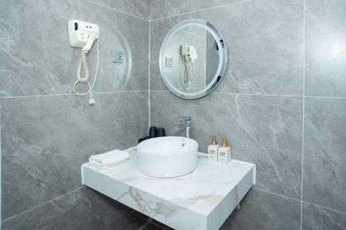 a bathroom with a white sink and a mirror at Sao Mai Bac Ha Hotel in Bắc Hà