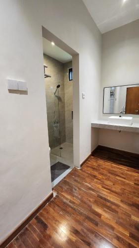 a bathroom with a sink and a shower at Cypress Resort Cipanas in Barukupa