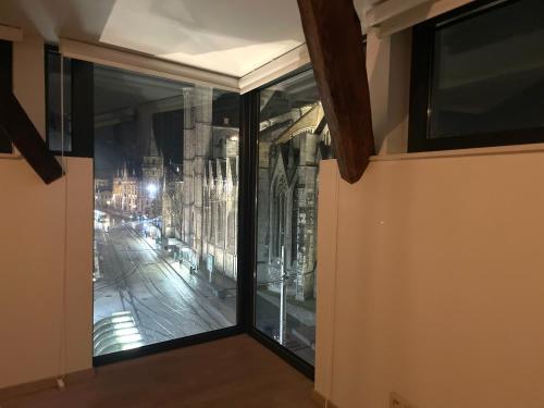 a room with a window with a view of a city at Historic Centre Duplex - Ghent Belfry & St Nicholas Church View in Ghent