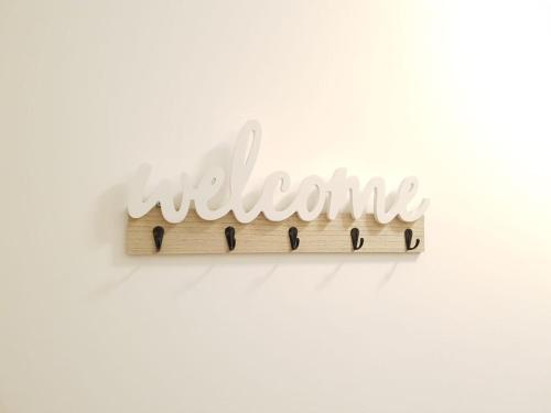 a wooden sign with the word welcome on a wall at A50 Apartments Stoke - 3 Bedrooms - 3 Bathrooms incl 2 ensuites house in Stoke on Trent