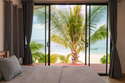 a bedroom with a bed and a view of the beach at IBIZA BEACH Resort in Haad Yao