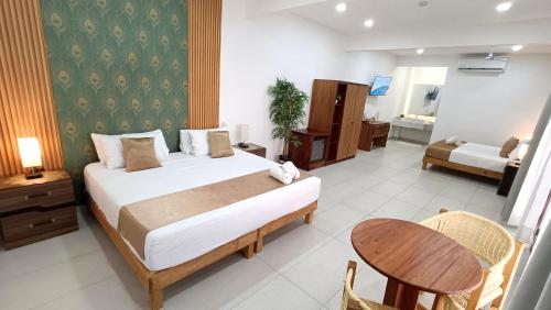 a bedroom with a bed and a table and a room at Punta Colibrí in Brisas de Zicatela