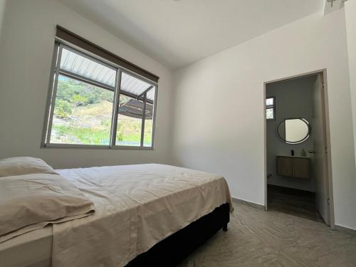a bedroom with a bed and a window and a mirror at Villa Majo in Nocaima
