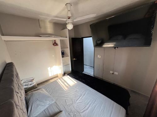 a small bedroom with a bed and a window at Casa Pacifico Azul in Ixtapa
