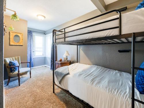a bedroom with two bunk beds and a chair at The Nest with Firepit & Backyard Oasis in Klamath Falls