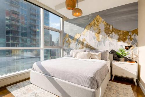 a bedroom with a white bed and a large window at Summit Mountain & Skyline Views Beltline in Calgary