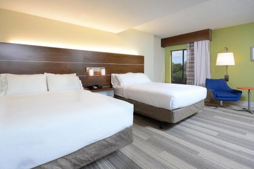 a hotel room with two beds and a desk at Holiday Inn Express & Suites Raleigh Durham Airport at RTP by IHG in Durham