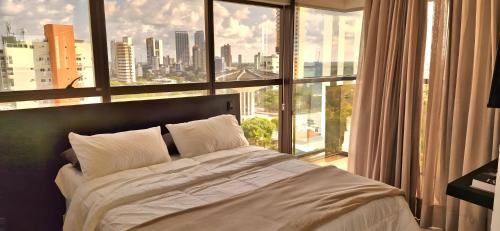 a bedroom with a bed in front of a large window at Reserva Madero Loft in Natal