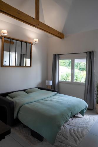 a bedroom with a large bed and a window at Carrière de la Tour in Condé-sur-Sarthe