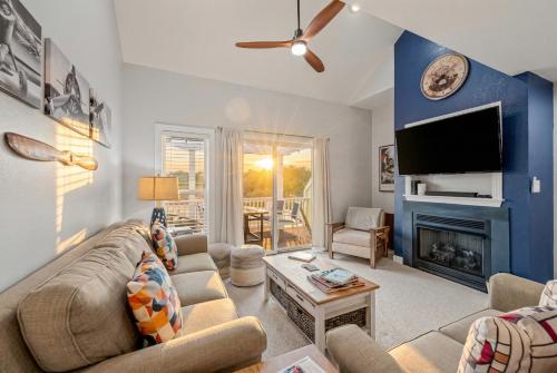 a living room with a couch and a fireplace at The Wright Stuff OBX in Kill Devil Hills