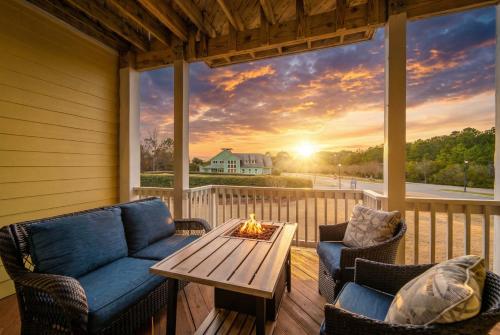 a screened porch with a table and chairs and a fireplace at The Wright Stuff OBX in Kill Devil Hills