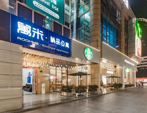a large building with lights on it at night at RoomMe HOTEL寓洣公寓佛山铂顿祖庙岭南天地店 in Foshan