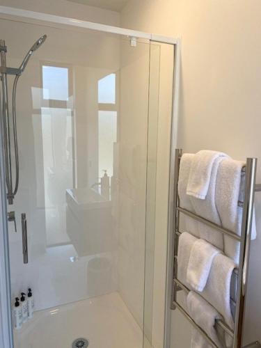 a bathroom with a shower and a sink and towels at Colombo Executive Apartments in Christchurch