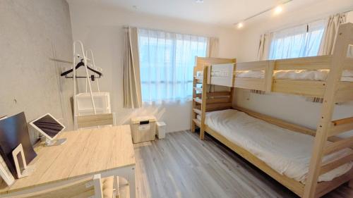 a room with two bunk beds and a desk at KamaKama Stay in Tokyo
