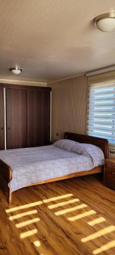 a bedroom with a large bed with a wooden floor at Cabañas San Pedro in Arauco