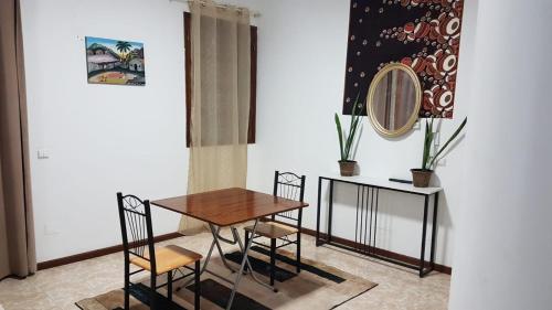 una sala da pranzo con tavolo, sedie e uno specchio di Topklass homes a Praia